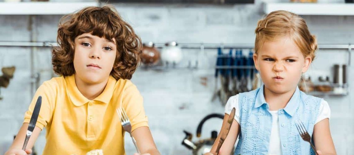 stock-photo-cute-unhappy-kids-holding-cutlery